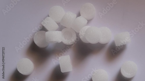 White camphor tablets scattered on a plain surface