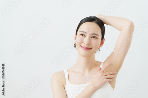 Canvas Print 白背景の脇に手を当てて微笑む若い日本人女性　脱毛イメージ