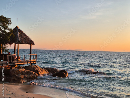 Relaxing sunset view from a tranquil beachside gazebo in Klaeng, Thailand