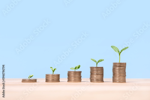 Tableau sur toile Young green seedlings plant growing on increasing coin stacking for money saving