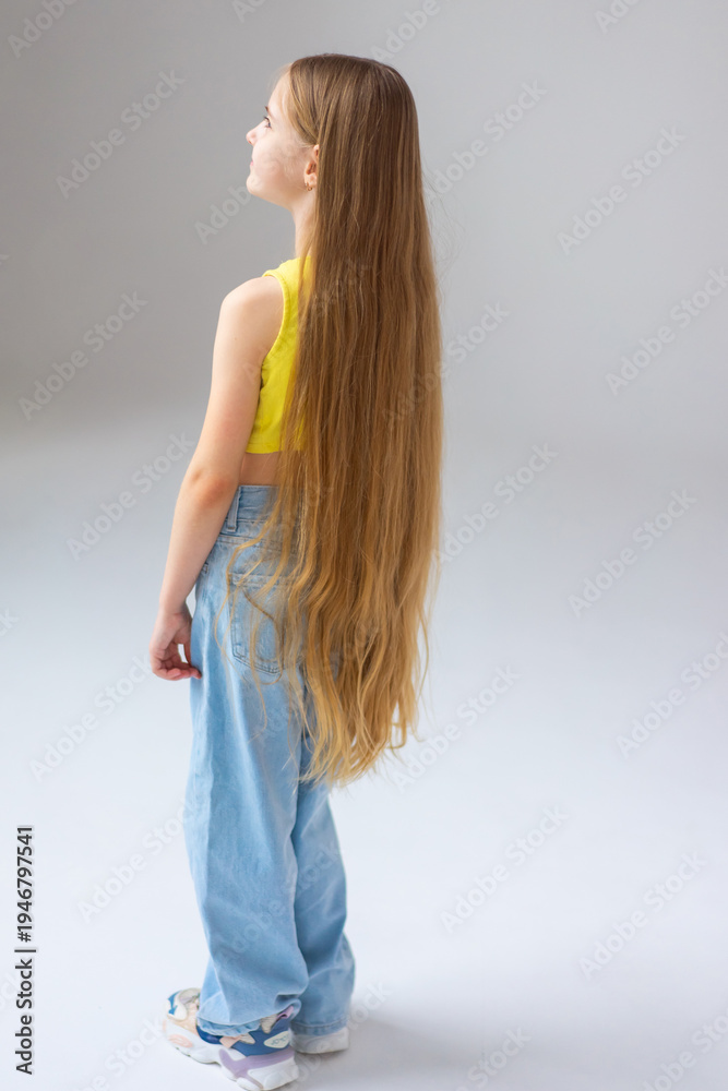 Fototapeta premium Happy little girl model with long blondie hair. Emotional, cheerful, joyful, cute, adorable caucasin girl posing in studio