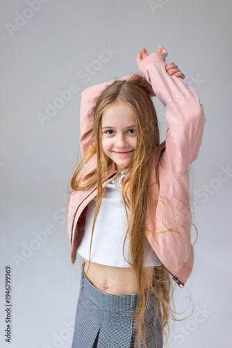 Happy little girl model with long blondie hair. Emotional, cheerful, joyful, cute, adorable caucasin girl posing in studio
