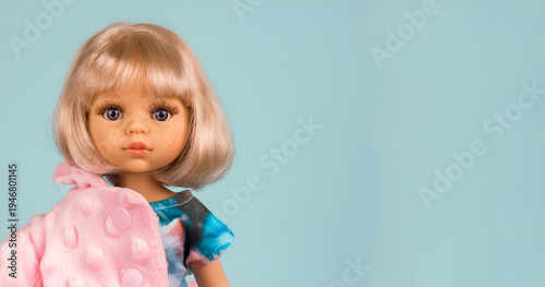 Doll toy with beautiful blond hair and a cute face close-up portrait, sale of children's toys, doll fashion, selective focus
