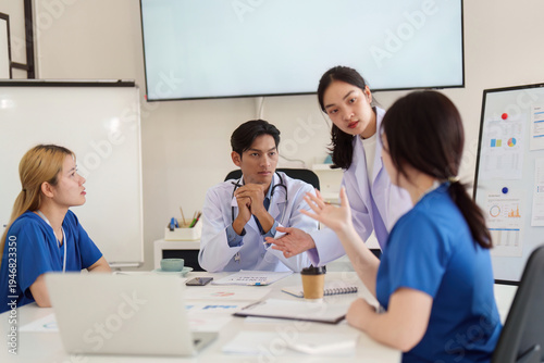 Healthcare Team Collaboration. Medical professionals discussing patient care strategies in a modern office.