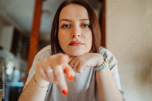 Photos Woman pointing finger directly at viewer with intense gaze