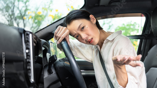 Canvastavla Beautiful Asian female driver looks frustrated and confused inside her car after encountering a mechanical problem