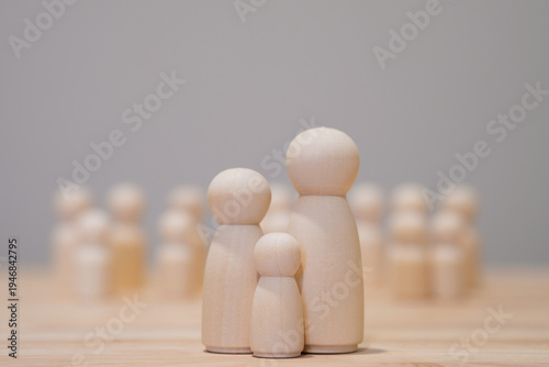 Foto Conceptual wooden dolls forming a small family illustrating parenting responsibility, social expectations and hope parents have for their children success