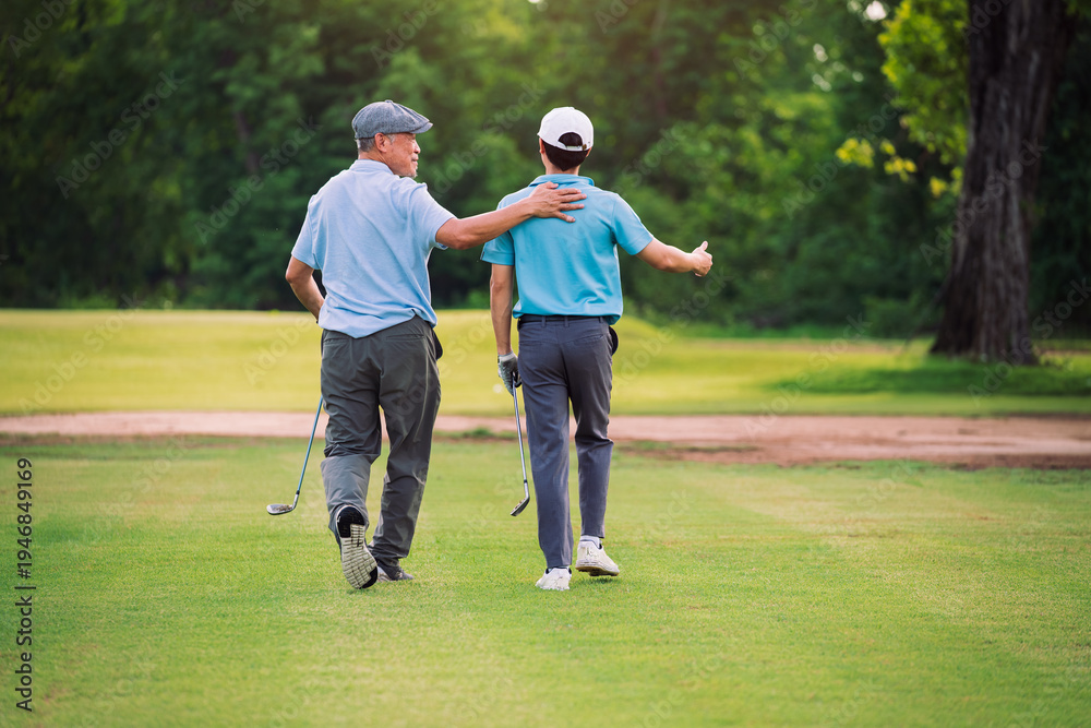 Obraz premium Senior golfer guiding younger player while walking across golf course fairway, mentorship sport relationship and outdoor recreation concept