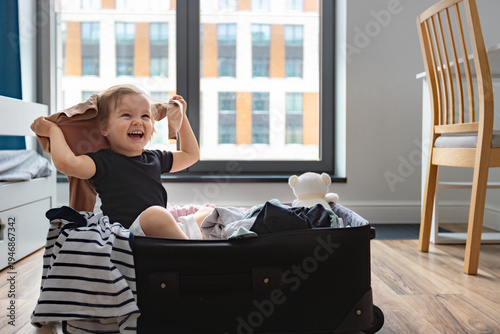 Baby in Travel Suitcase. Kid inside Luggage Packed for Vacation Full of Clothes, Family Trip