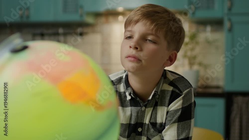 Boy Examining Globe at Home