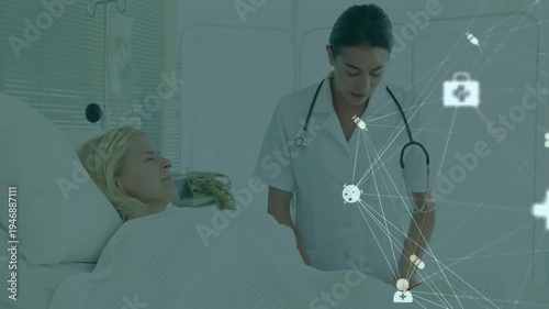 Nurse arriving bedside and reviewing medical network icons while placing hand to reassure patient