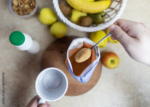 Wallpaper Mural Person adding apple fiber powder to a glass of yogurt, surrounded by fresh apples and walnuts. Healthy prebiotic supplement for gut health, digestion and weight management. Torontodigital.ca