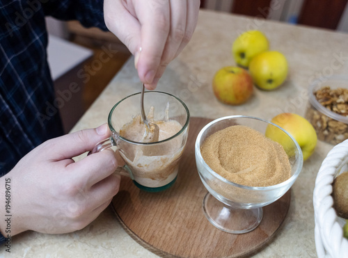 Wallpaper Mural Person adding apple fiber powder to a glass of yogurt, surrounded by fresh apples and walnuts. Healthy prebiotic supplement for gut health, digestion and weight management. Torontodigital.ca