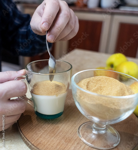 Wallpaper Mural Person adding apple fiber powder to a glass of yogurt, surrounded by fresh apples and walnuts. Healthy prebiotic supplement for gut health, digestion and weight management. Torontodigital.ca