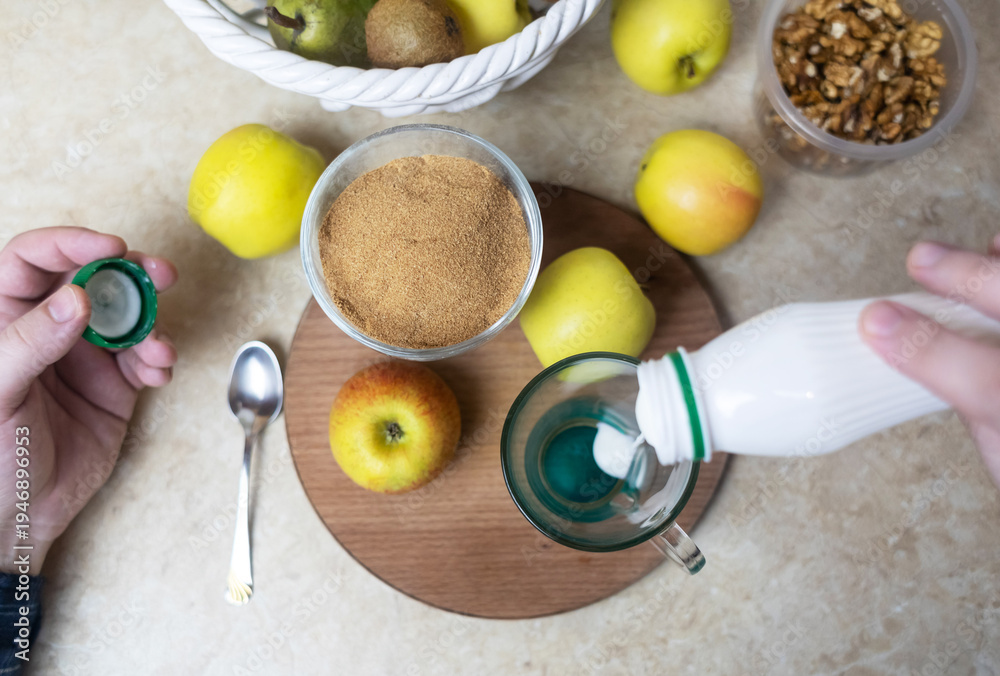 custom made wallpaper toronto digitalPerson adding apple fiber powder to a glass of yogurt, surrounded by fresh apples and walnuts. Healthy prebiotic supplement for gut health, digestion and weight management.