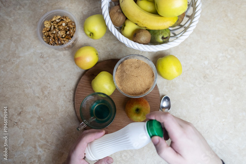 Wallpaper Mural Person adding apple fiber powder to a glass of yogurt, surrounded by fresh apples and walnuts. Healthy prebiotic supplement for gut health, digestion and weight management. Torontodigital.ca