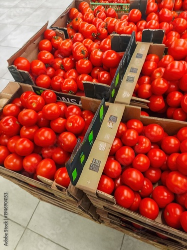 Fresh red tomatoes in wooden crates displayed at grocery store produce section with vibrant color and market vegetable arrangement