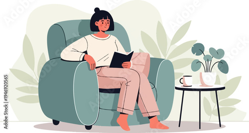 Person relaxes in armchair reading book next to table with plant and mug