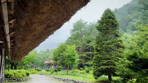 4K Cinematic shot under thatched roof eaves in Shirakawa-go village during summer rain, Japan