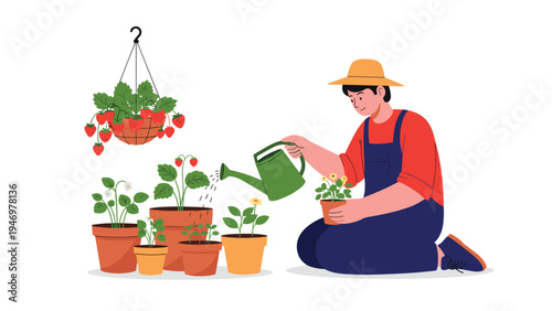 Young male gardener wearing a straw hat and overalls watering potted plants and flowers with a green watering can in his garden.