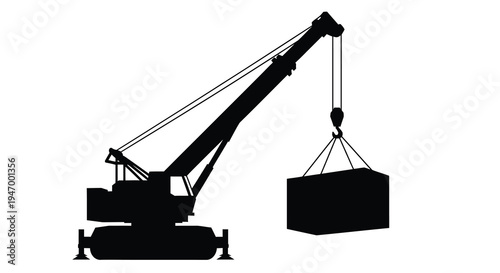 Construction crane lifting a large container a stark black silhouette