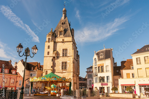 The beautiful medieval belfry (the first townhall) and surrounding city square with merry-go-round in Dreux, France