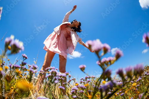 Happy woman enjoying nature outdoors among flowers. Outdoors.