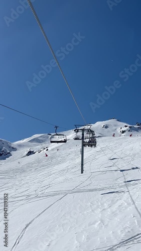 Ski lifts going up and down in Courchevel ski resort, French alps, France on a sunny blue sky day