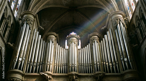 Organ pipes in a cathedral with stained glass windows