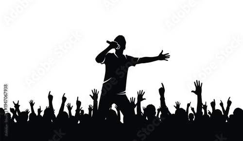 A silhouette of a male singer performing on stage with a large crowd of fans cheering in front