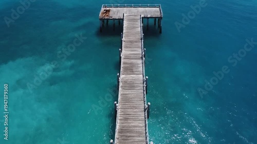 Aerial View of Long Wooden Pier Over Turquoise Ocean Water