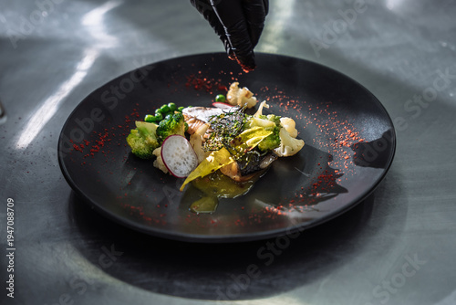 Exquisite seafood dish with salmon fillet broccoli and radish on a black designer plate