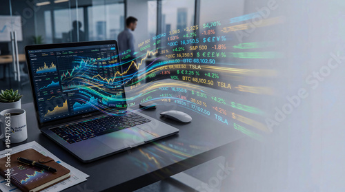 Laptop displays vibrant financial charts and data streams. Person stands in the background, focused on the screen. Digital numbers float mid-air, suggesting real-time market activity