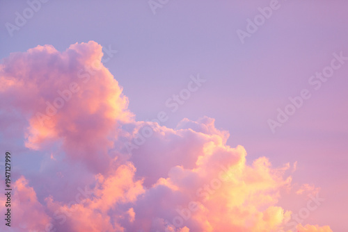 Cuadro en lienzo Beautiful fluffy cumulus clouds in a vibrant sunset sky with soft pastel shades of pink, purple, and orange