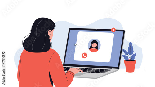 Young woman sitting at a desk and video calling a friend on her laptop for a remote conversation and social interaction from home.