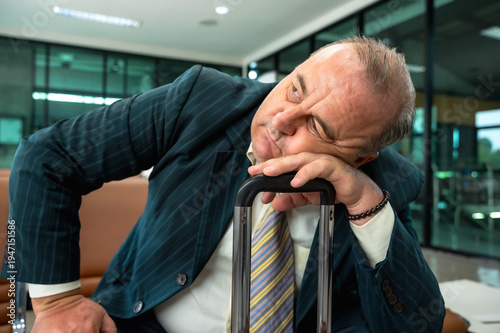 Fotografia Elderly businessman feeling bored and sleepy while waiting going onboard for too