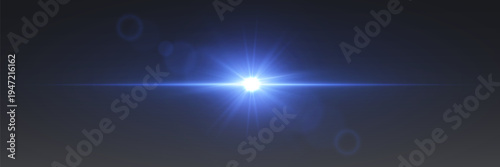 Bright blue lens flare light with glowing rays and optical glare on dark background.
