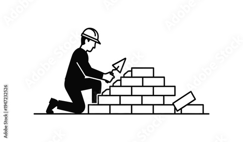A construction worker wearing a hard hat while laying bricks with a trowel at a building site