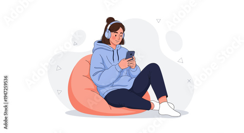 Teenager listening to music on headphones and using smartphone while sitting on bean bag