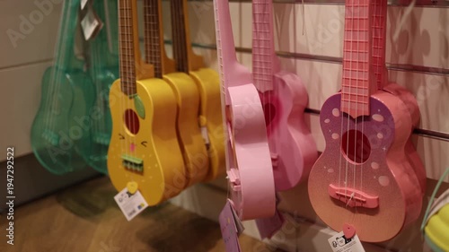 Colorful ukulele guitars hanging on retail store wall display representing music hobby learning instruments children creativity entertainment and beginner acoustic music concept