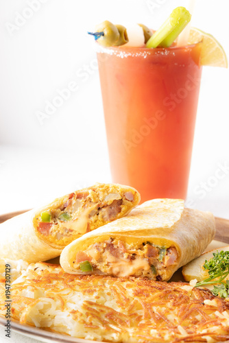 Breakfast burrito with hash browns and Bloody Mary cocktail