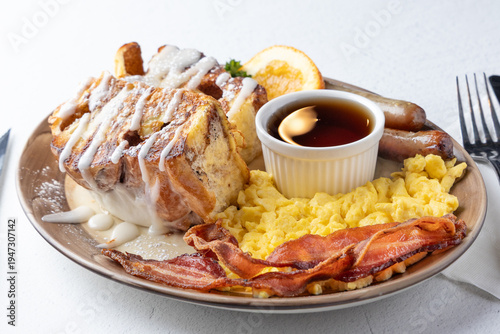 Cinnamon roll French toast breakfast with eggs, bacon and sausage