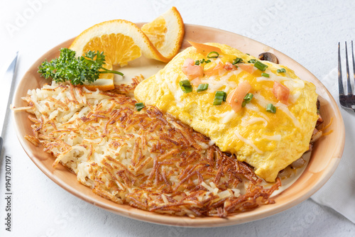 cheese omelette breakfast with hash browns and orange slices