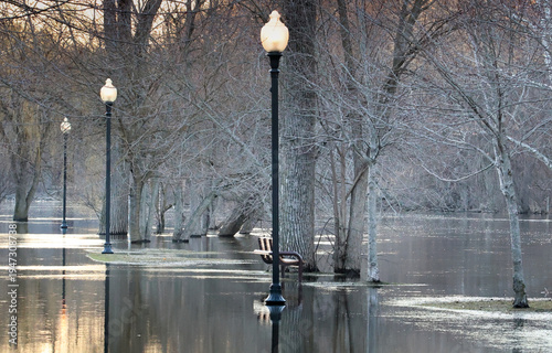The river flooded the sidewalk and trees on Grand Ledge, Michigan