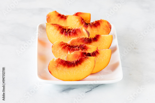Bilde på lerret Fresh free stone peach segments on a small platter, ready for eating