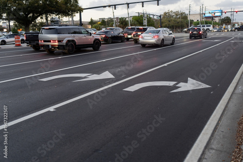Obraz na plátně Cars moving and waiting through a large signalized intersection, with turn lane
