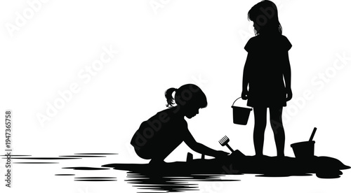 Silhouette of two young girls playing with sand and water at the beach with buckets and toys children