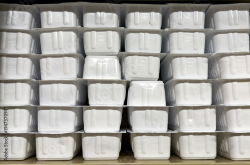 Stacked white medical specimen containers stored on hospital shelf