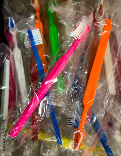 Colorful disposable toothbrushes in individual plastic packaging