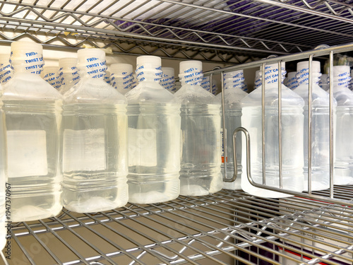 Clear plastic medical containers stored on hospital supply shelf